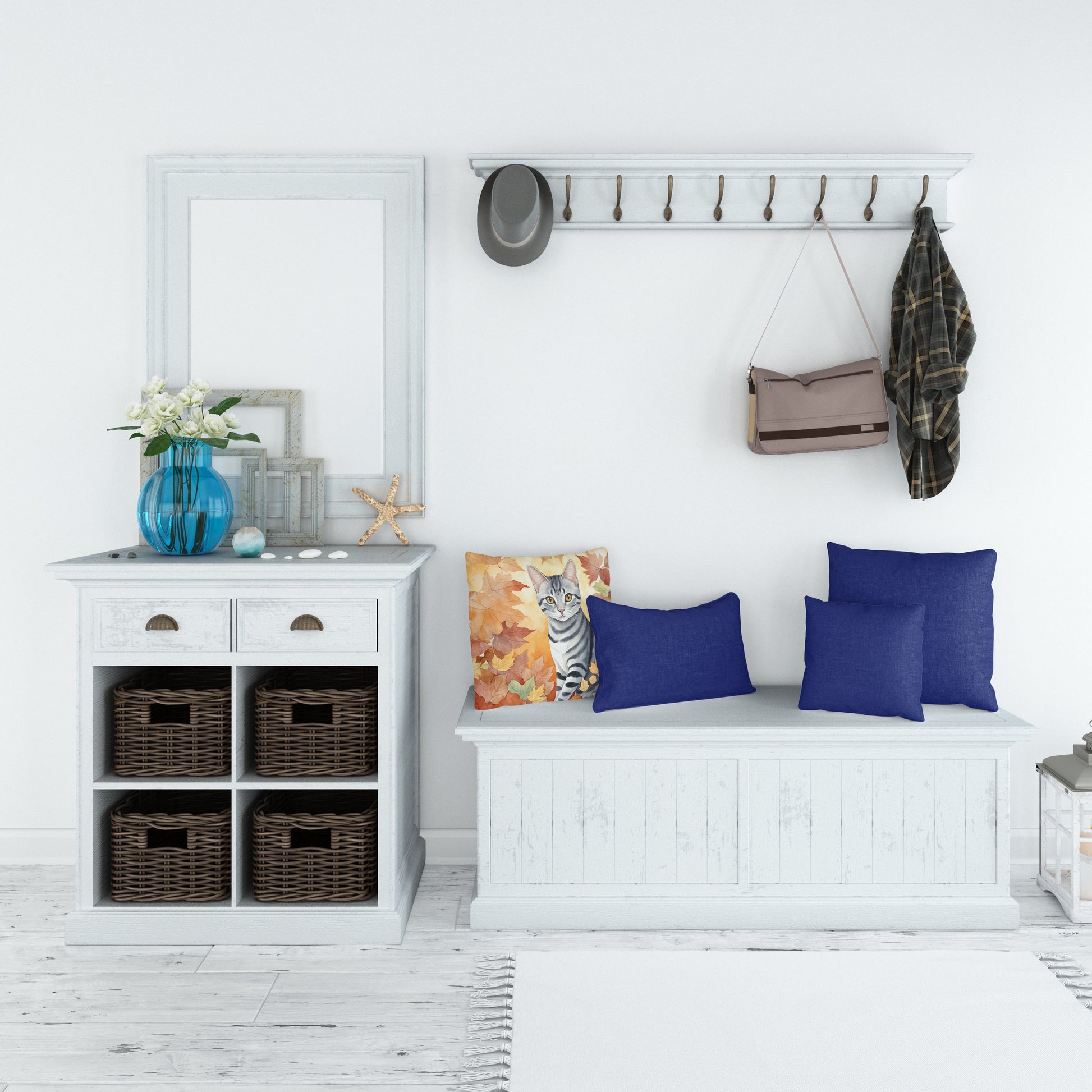 Cozy white entryway with white furniture, wicker baskets, and blue accents. Coat rack with hat, bag, and shirt. White rug.
